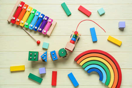 Toy train with building blocks and xylophone on yellow wooden backgroundの写真素材