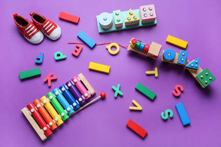 Educational toys and baby boots on purple backgroundの写真素材