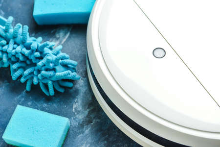 Robot vacuum cleaner, sponges and dust brush on color background, closeupの写真素材