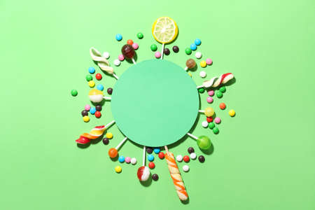 Composition with blank card, lollipops and candies on green backgroundの写真素材