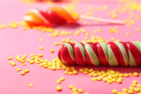Sweet lollipops and colorful sprinkles on color background, closeupの写真素材