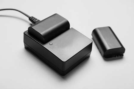 Camera battery and charger on gray background