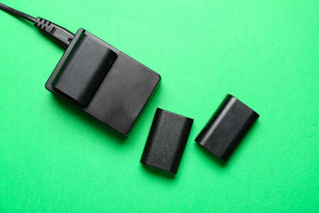 Camera batteries and charger on green backgroundの写真素材