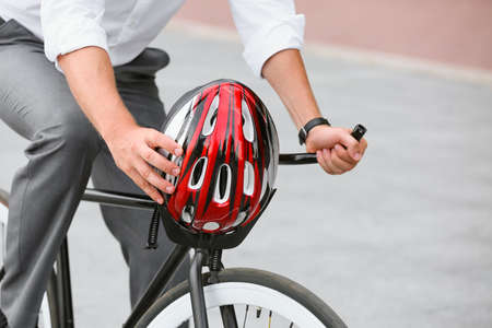 Man with bicycle and helmet on city street