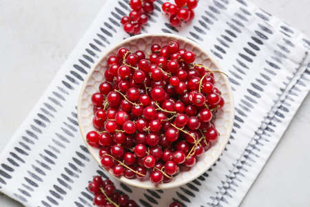 Bowl with tasty red currants on light backgroundの写真素材