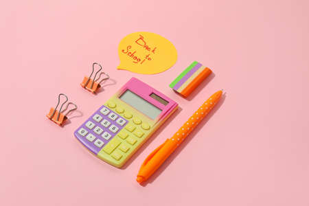 Paper with text BACK TO SCHOOL and stationery on color background