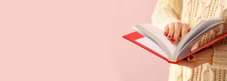 Young woman reading book on pink background with space for text
