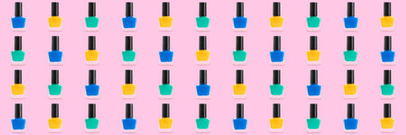 Many bottles of nail polishes on pink background. pattern for designの写真素材