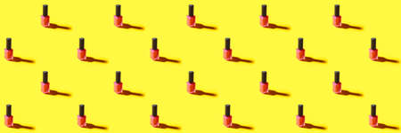Many bottles of nail polish on yellow background. pattern for designの写真素材