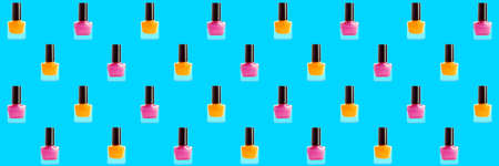 Many bottles of nail polishes on light blue background. pattern for design
