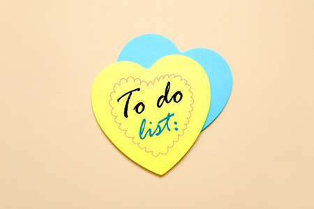 Heart-shaped note papers with blank to-do list on color background