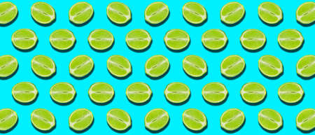 Many halves of fresh juicy lime on blue background. pattern for designの写真素材