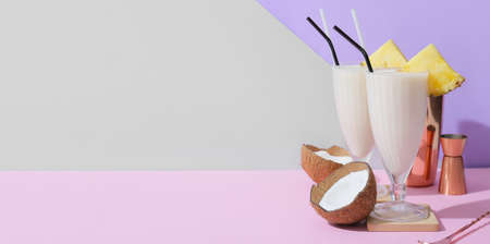 Glasses of tasty Pina Colada cocktail on color background with space for textの写真素材