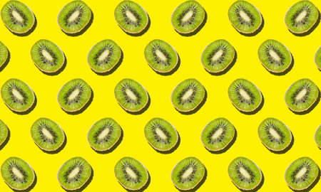 Many cut kiwis on yellow background. pattern for design