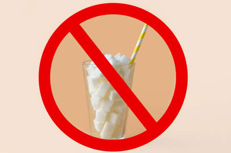 Sugar cubes in glass and prohibition sign on color backgroundの写真素材