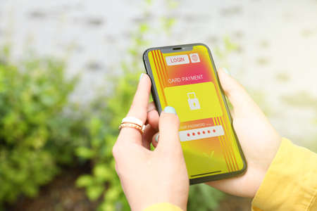 Young woman with modern smartphone outdoors, closeup. Concept of payment online