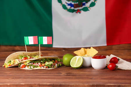 Composition with Mexican traditional food and flags on wooden tableの写真素材