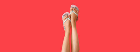 Legs of young woman in flip-flops on red background. Banner design