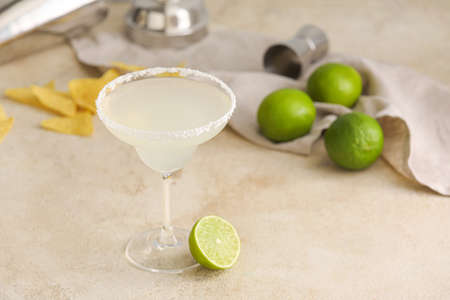 Glass of tasty margarita cocktail on table, closeup