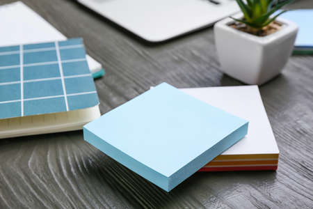 Stack of blank sticky notes on gray wooden table, closeup