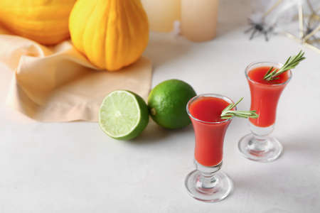 Shots of tasty bloody Mary cocktail with rosemary on light backgroundの写真素材
