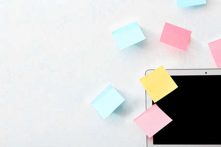 Modern laptop and different sticky notes on white wall