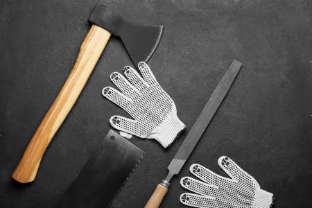 Ax, back saw, rasp and gloves on dark backgroundの写真素材