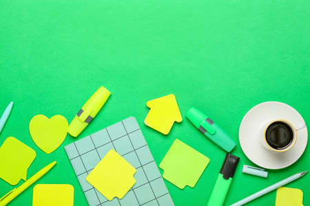 Different sticky notes, notebook, markers, pens and cup of coffee on color backgroundの写真素材