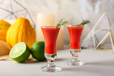 Shots of tasty bloody Mary cocktail with rosemary on light backgroundの写真素材