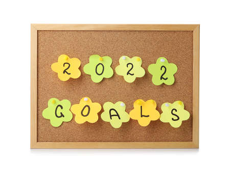 Board with sticky notes, figure 2022 and word GOALS on white background