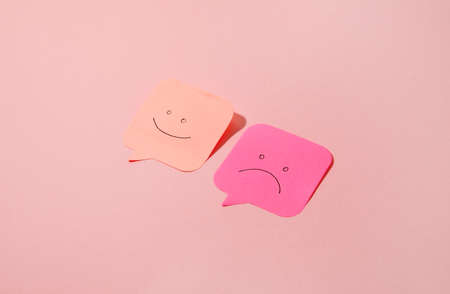 Sticky notes with drawn faces on pink background