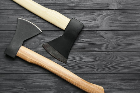 Sharp axes on dark wooden backgroundの写真素材