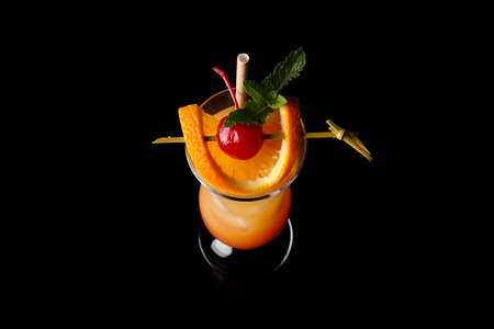 Glass of tasty Tequila Sunrise cocktail on dark backgroundの写真素材