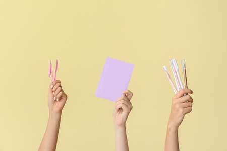 Female hands with school supplies on color background