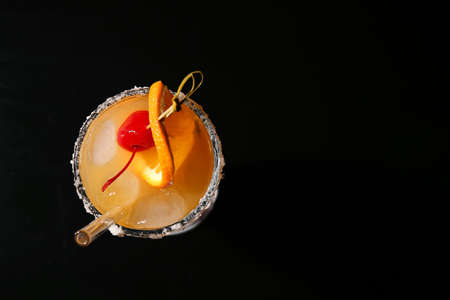 Glass of tasty Tequila Sunrise cocktail on dark backgroundの写真素材