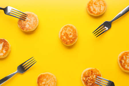 Cottage cheese pancakes and forks on color backgroundの写真素材