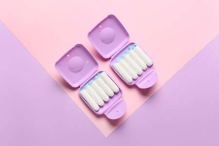 Tampons storage boxes on pink and lilac background, top viewの写真素材