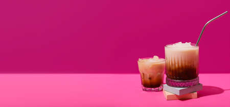 Glasses of White Russian cocktail on pink background with space for textの写真素材
