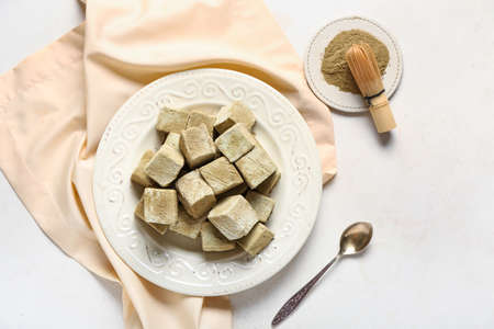 Plate with tasty hojicha marshmallows and chasen on light background