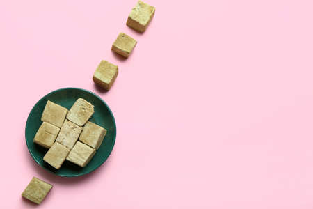 Plate with tasty hojicha marshmallows on pink background