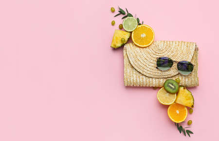 Composition with bag, sunglasses and fruits on color background
