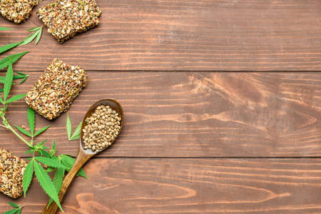 Protein bars with hemp seeds, spoon and bush on wooden backgroundの写真素材