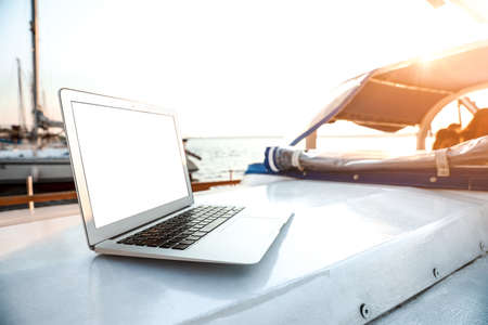 Modern laptop with blank screen on yachtの写真素材