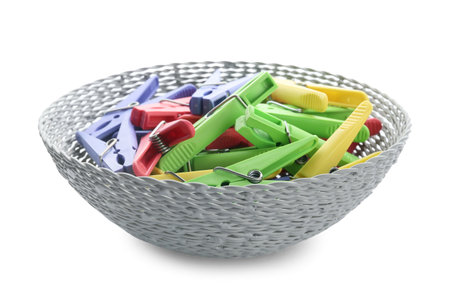 Wicker bowl with plastic clothes pins on white backgroundの写真素材