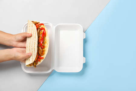 Female hands with tasty Fajitas on color backgroundの写真素材