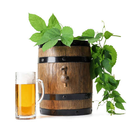 Wooden barrel and mug of fresh beer with hop branch on white background. Oktoberfest celebrationの写真素材