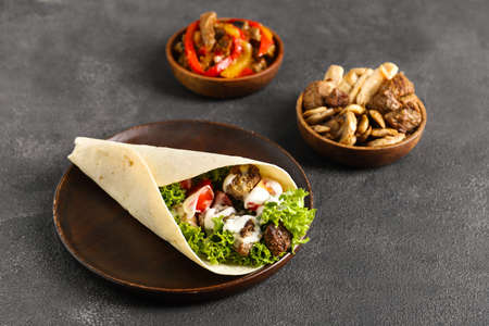 Plate with tasty Fajitas and ingredients on dark backgroundの写真素材