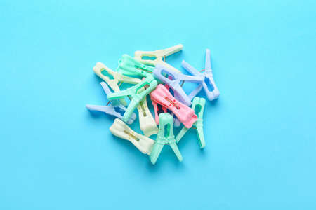 Plastic clothes pins on color background