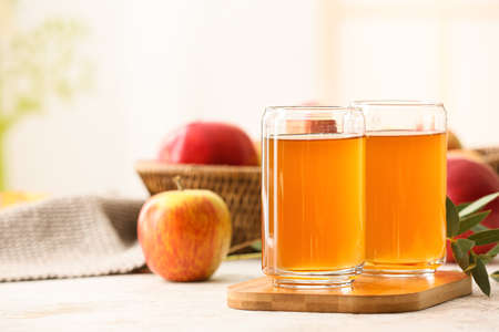 Glasses of apple juice on table