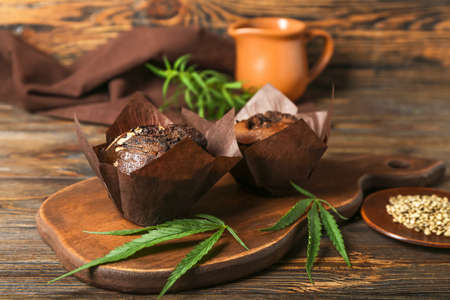 Board with chocolate hemp muffins and leaves on wooden backgroundの写真素材